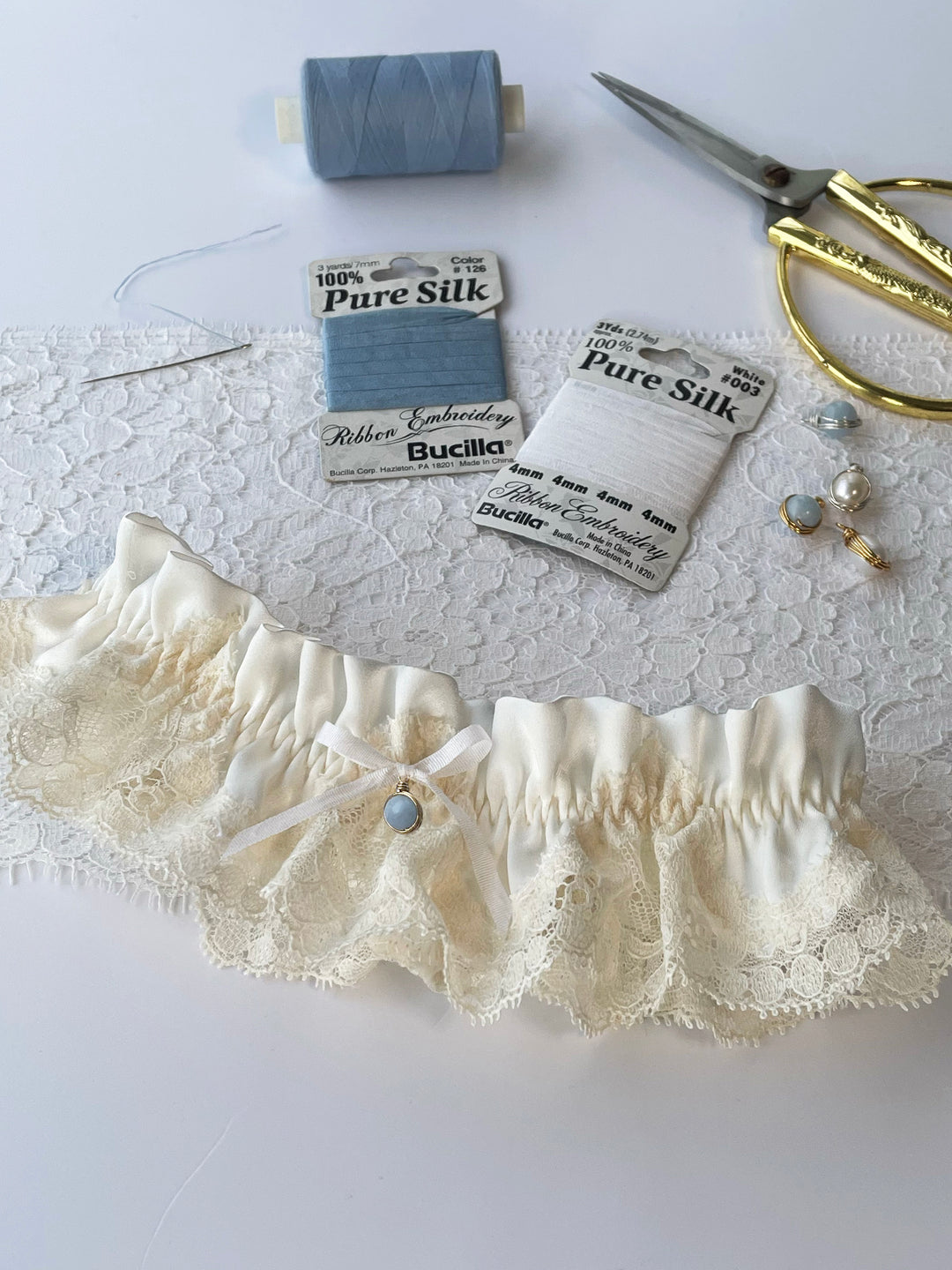 Harper ivory silk garter close-up with white satin bow and lace detail - handmade bridal lingerie Brighton