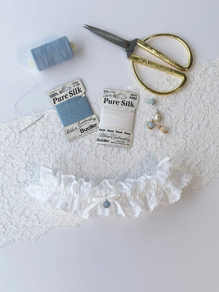 Clara white lace garter with white bow close-up showing handcrafted detail - luxury bridal accessory