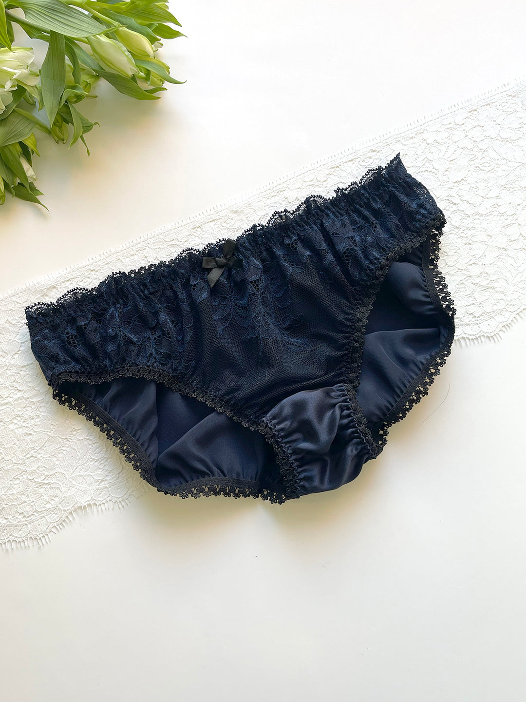Camilla navy silk and lace knicker on lace background - handmade luxury lingerie Brighton