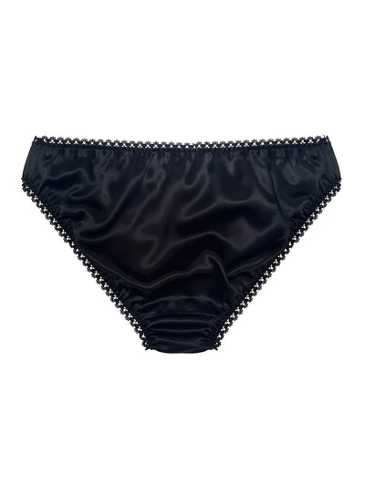 Black satin underwear with lace trim on a white background by Ayten Gasson