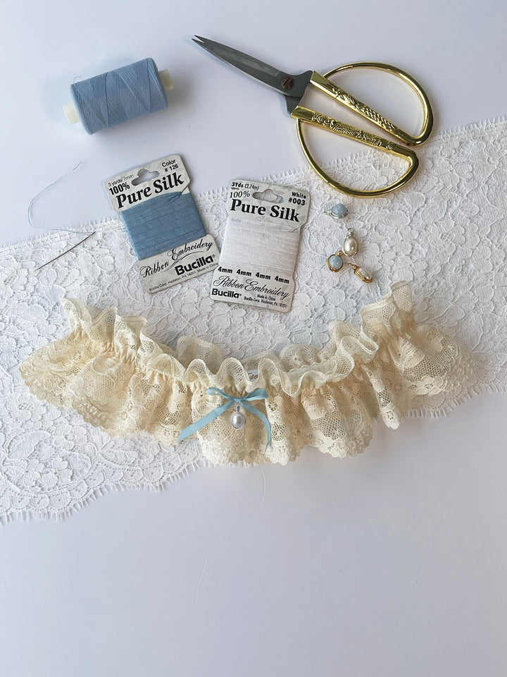 Harper cream lace bridal garter with blue satin bow detail and detachable pearl pendant