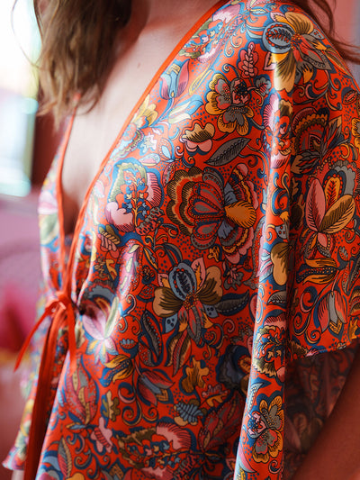 Close-up of a colorful patterned garment with vibrant orange, red, and blue colors.