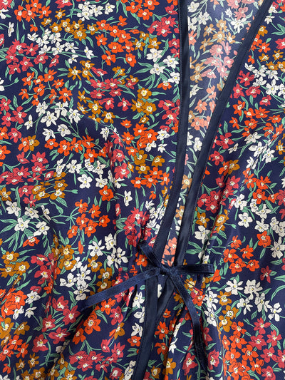Sea Blossom Liberty Navy Silk Bed Jacket with a tie detail on a dark blue background