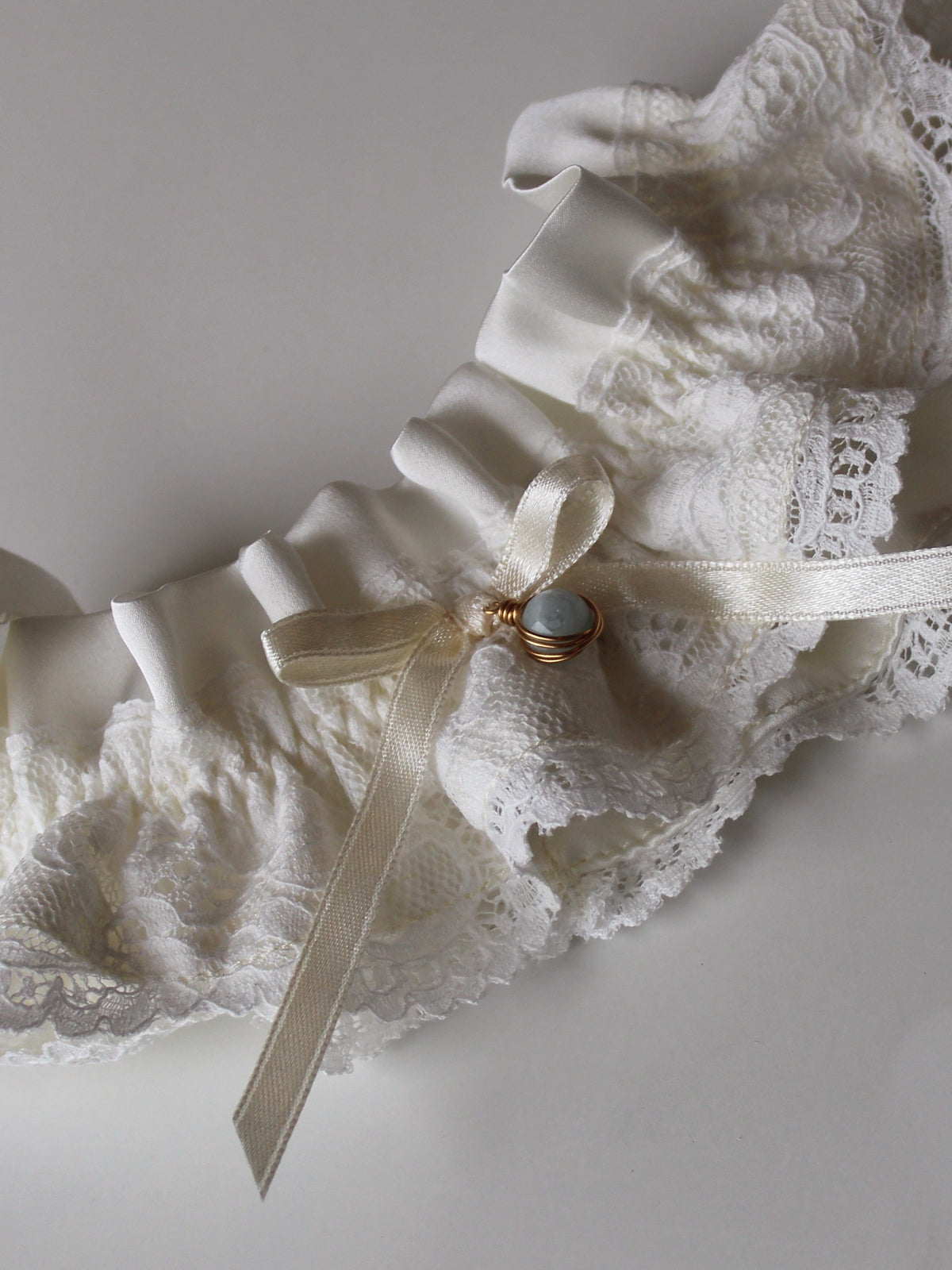 Customizable silk garter with floral lace, gemstone pendant, and hand-tied ribbon bow